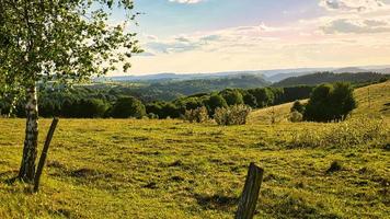 A sunny day in the Saarland with a view over meadows into the valley. photo