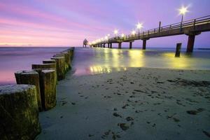 the pier in Zingst on the Baltic Sea, with a long exposure and purple pastel colors photo