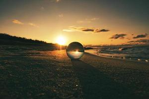 Glass globe on the beach of the Baltic Sea in Zingst in which the landscape is depicted. photo