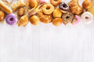 assorted junk food multiple type on white wooden table of top view with copy space photo