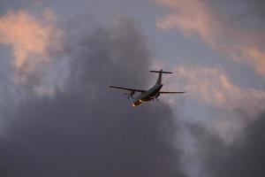 airplane in the evening sky in luminous horizon. photo