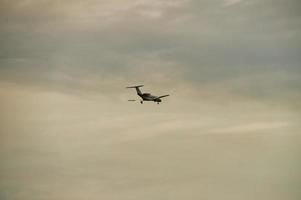 airplane in the evening sky in luminous horizon. photo