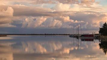 the Bodden near Zingst on the Baltic Sea in the evening hours. are reflected in the calm water. photo