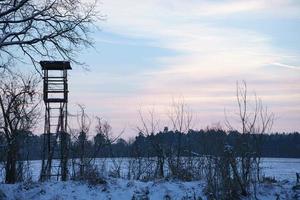 High stand for hunting in a winter snowy landscape. photo