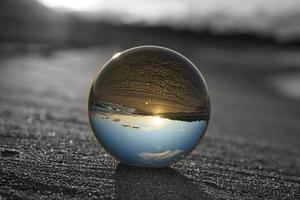 Glass globe on the beach of the Baltic Sea in Zingst in which the landscape is depicted. photo