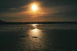 puesta de sol en zingst en el mar. el sol rojo anaranjado se pone en el horizonte. círculo de gaviotas en el cielo foto