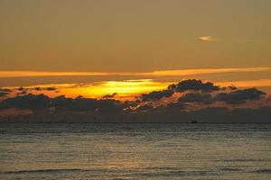 Sunset by the sea in colorful light show in the clouds photo