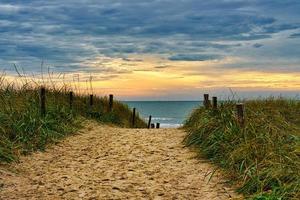 Dune crossing on the beach in Blavand, Denmark overlooking the sea photo