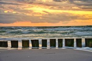 sunset on the beach of the Baltic Sea. Groynes in front of the sea and sky. photo