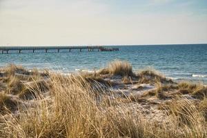 on the beach of the baltic sea with clouds, dunes and beach. Hiking in spring. photo