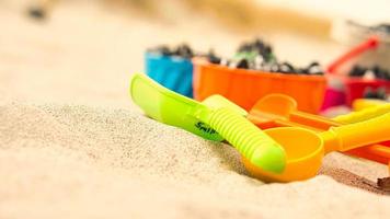 colorful toys on the beach for children to dig. Sand is used to build castles and shapes photo