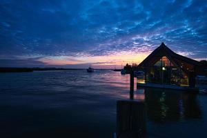 from the harbor in zingst the bodden view with burning sky with house. photo