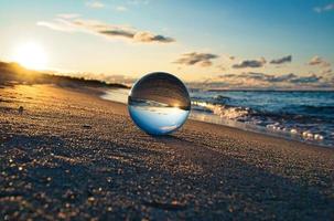 Glass globe on the beach of the Baltic Sea in Zingst in which the landscape is depicted. photo