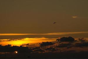 Sunset by the sea in colorful light show in the clouds photo