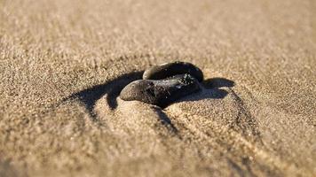 piedra en forma de corazón en la arena de la playa en el mar Báltico foto