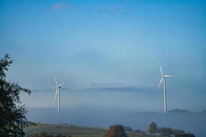 Windmill in foggy landscape. Renewable energy for environmentally conscious future photo