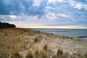 View over the dunes to the Baltic Sea at sunset. Vivid colors in the sky. Dune photo