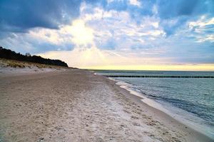 On the beach of the Baltic Sea. Sunset, groynes, beach and sand. Landscape shot photo