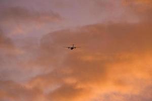 airplane in the evening sky in luminous horizon. photo