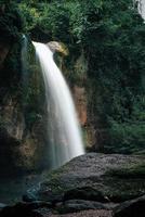 A natural waterfall in a big forest in the midst of beautiful nature. photo