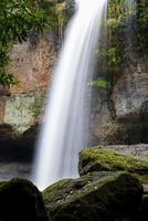 A natural waterfall in a big forest in the midst of beautiful nature. photo