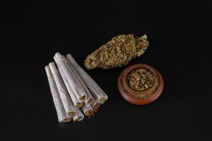 bud, mountain of joints and full grinder on a black background photo