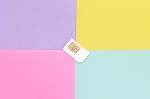 Subscriber identity module. White SIM card on pastel background photo