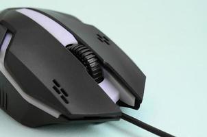 Closeup of a black gaming optical mouse on a blue background photo