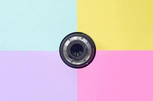 Minimalism with photographic lens on blue, violet, pink and yellow background photo