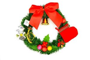 Christmas wreath decoration with Golden bell, Red sock, small santa claus, small colorful ball, gift box, red ribbon and green leaves isolated on white background. Chirstmas and Happy new year concept photo