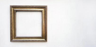 maqueta de marco de imagen dorada o marrón en pared de hormigón blanco con espacio de copia. marco aislado en el fondo. foto
