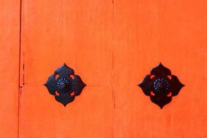 puerta de madera roja o naranja vintage para fondo con símbolo de acero inoxidable negro. papel tapiz de madera retro con línea de espacio agrietado y copia foto