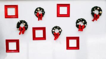 Christmas, happy new year wreath decoration with red ribbon, white ball and red picture frame for add wording isolated on white wall background. Object for decorated party, festival with copy space. photo