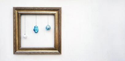 Empty colorful picture frame mockup with blue ball and light bulb hanging on white concrete wall with copy space for add or fill text. Framework on background. Decorate for festival, Celebrate party. photo