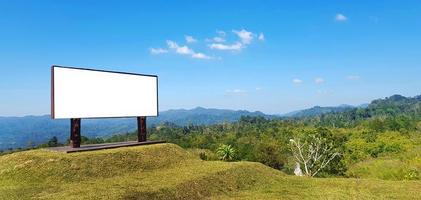 Empty or mockup sign for add or fill wording or text with forest or jungle, mountain, clear blue sky and cloud background at national park. Beautiful natural and Advertisement or Announcement concept photo