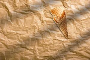Empty crispy ice cream cone isolated on brown paper. food concept element. photo