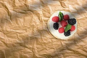 tortitas caseras frescas con fresas y arándanos sobre papel para hornear. concepto de panadería francesa foto