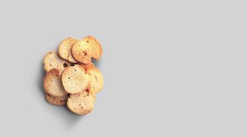 A closeup view of dry bread slices under the lights isolated on a grey background. photo