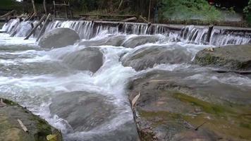 The stream flows through the rocks and rocks in the stream. video