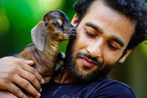 boy with cute baby goat pet animal photo