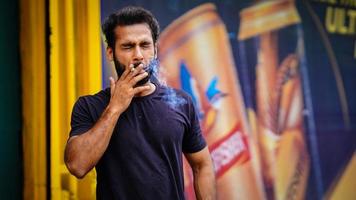 man smoking in market outdoor photo