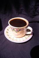 a glass containing brewed black coffee on a black background photo