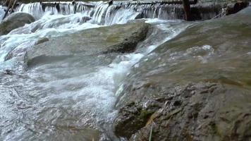 le ruisseau coule à travers les rochers et les rochers dans le ruisseau. video