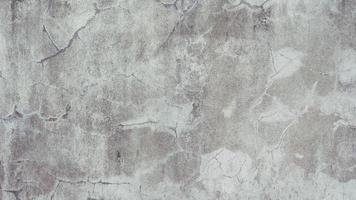 The old cement wall was weathered, the surface was scratched, the surface was scratched and damaged. For a mysterious retro-conservative background. photo