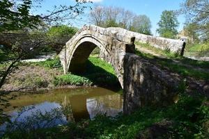 histórico puente de mendigo de piedra sobre el río esk foto