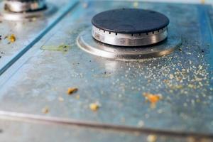 estufa sucia con salpicaduras de aceite, manchas de grasa y restos de comida foto