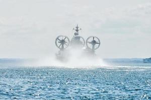 Landing Craft Air Cushion hovercraft flying above water, air cushion sailing splashing sea water photo