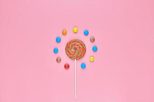 Sweet lollipop and candy on pink background photo