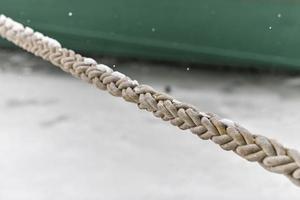 Rope tied ship on background of green ship side, close up photo