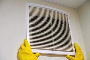 Holding ventilation grill of HVAC for cleaning or replacing. photo